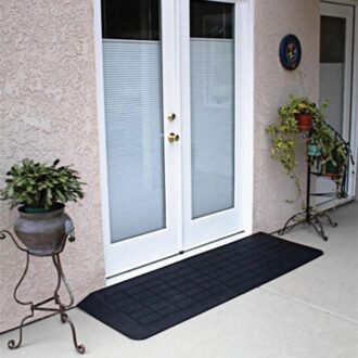 Small, rubber ramp butted up to the threshold of a French door.